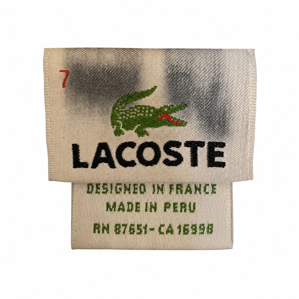アクア色のLacosteポロに付いたDEVANLAYケア表示