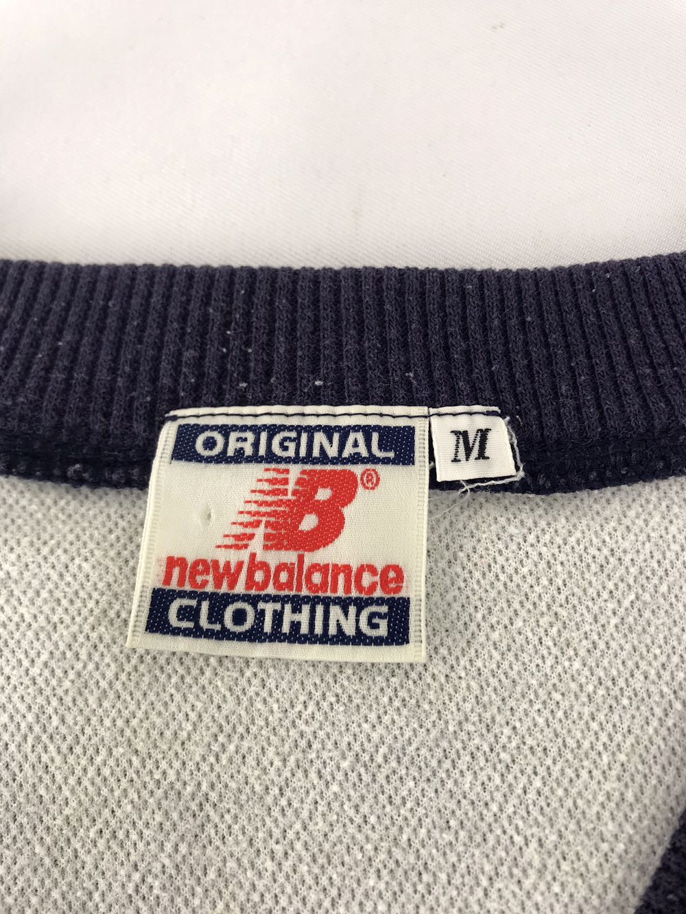 New Balanceの実物タグ資料、ブランドタグ全体。ロゴとタグの取り付け位置を確認する